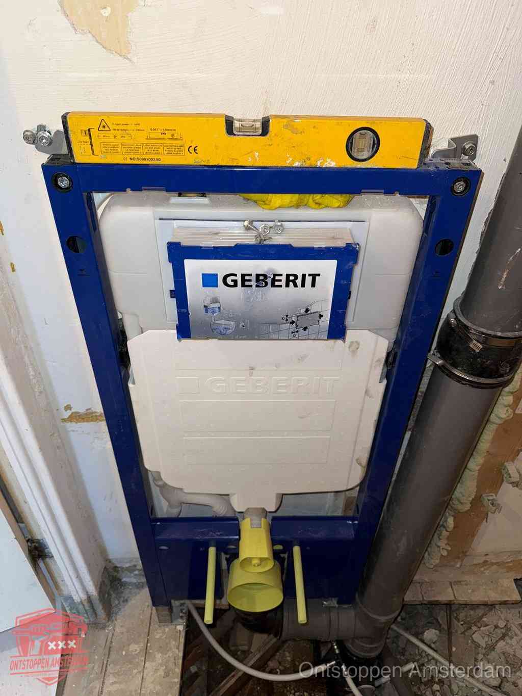 Een Geberit inbouwreservoir met frame voor een hangtoilet tegen de wand, met de afvoerbocht naar de vloer, kenmerkend voor een verstopt hangtoilet in Amsterdam