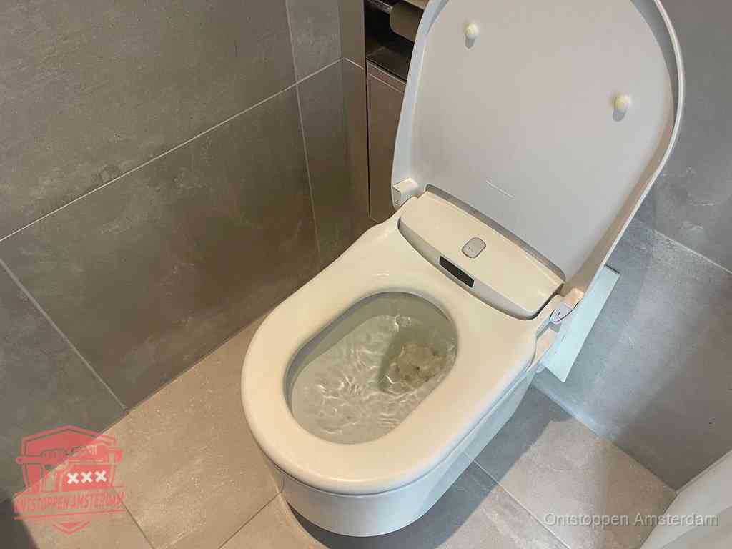 Een toiletpot vol troebel water met drijvend papier en restanten, de meest voorkomende oorzaak van een verstopte wc in Amsterdam