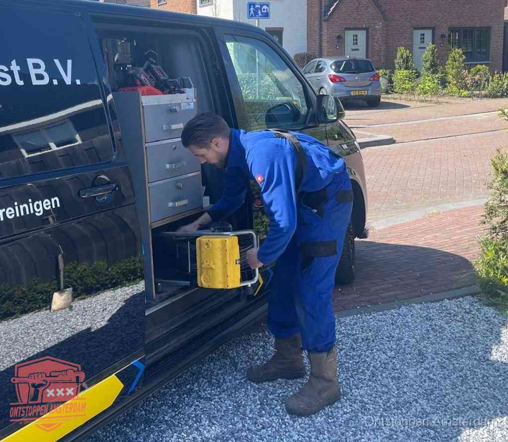 Een monteur pakt apparatuur uit de bedrijfsbus voor service aan huis, het moment om een professional in te schakelen in Amsterdam