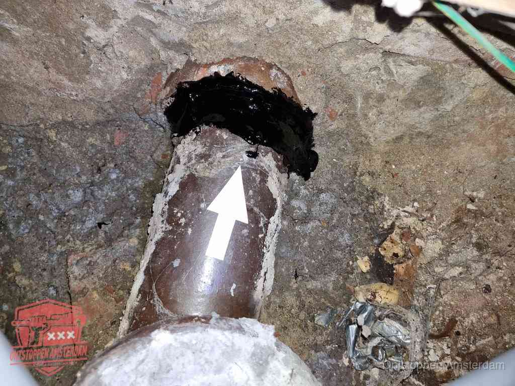 Een oude gres rioolbuis met een beschadigde koppeling onder de vloer, oorzaak van terugkerende structurele wc-problemen in Amsterdam