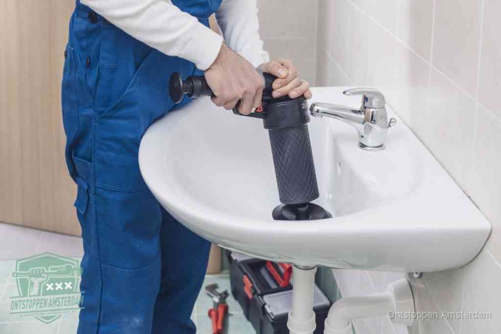 Een te ruwe doe-het-zelf poging met een hand-pomp op de afvoer van een badkamer-wastafel, een van de veelgemaakte fouten bij afvoer ontstoppen in Amsterdam