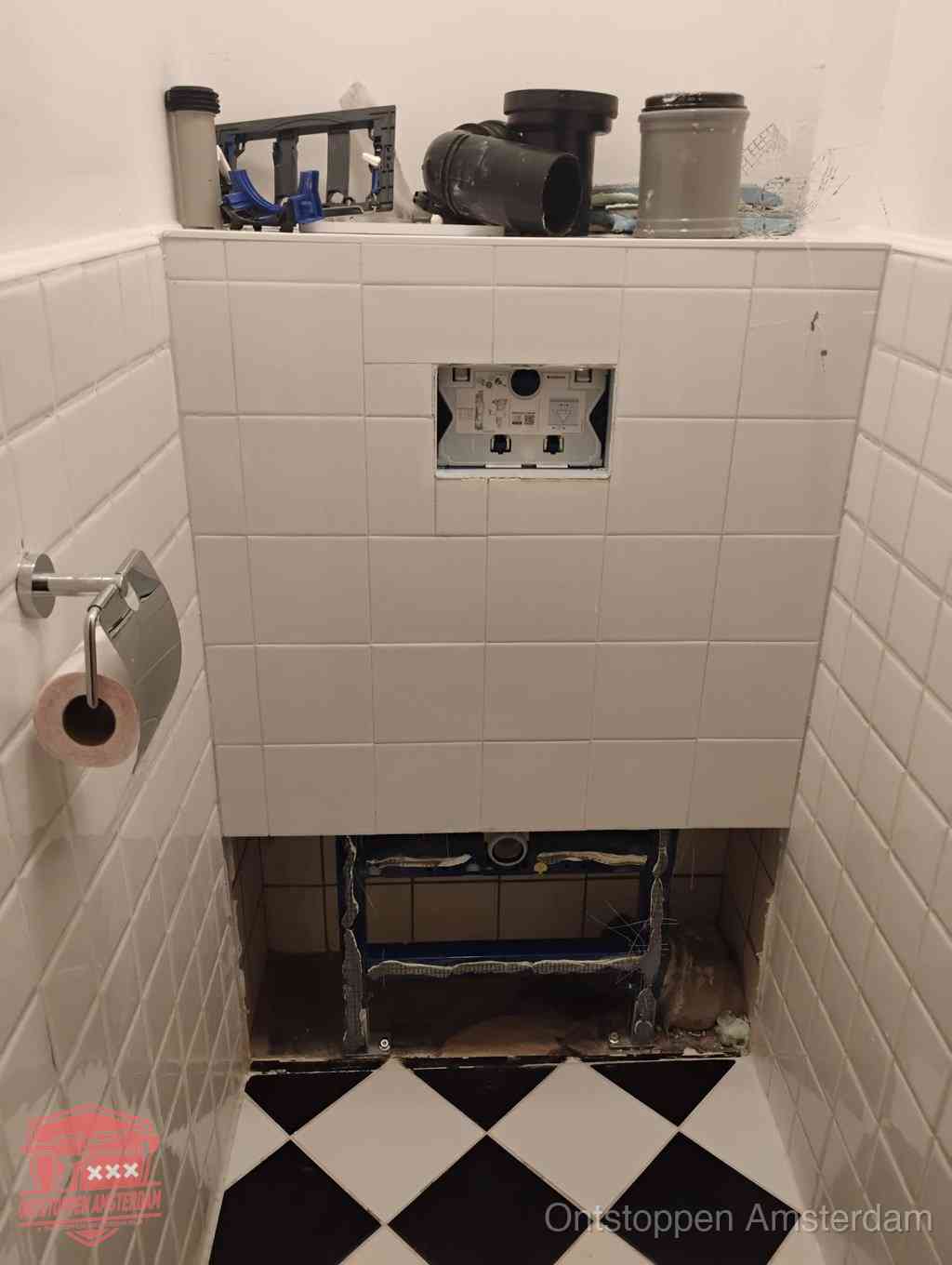 Een toiletruimte waar het hangtoilet en de inbouwreservoir-onderdelen zijn vrijgelegd voor onderhoud, periodiek nazicht voorkomt een wc-verstopping in Amsterdam
