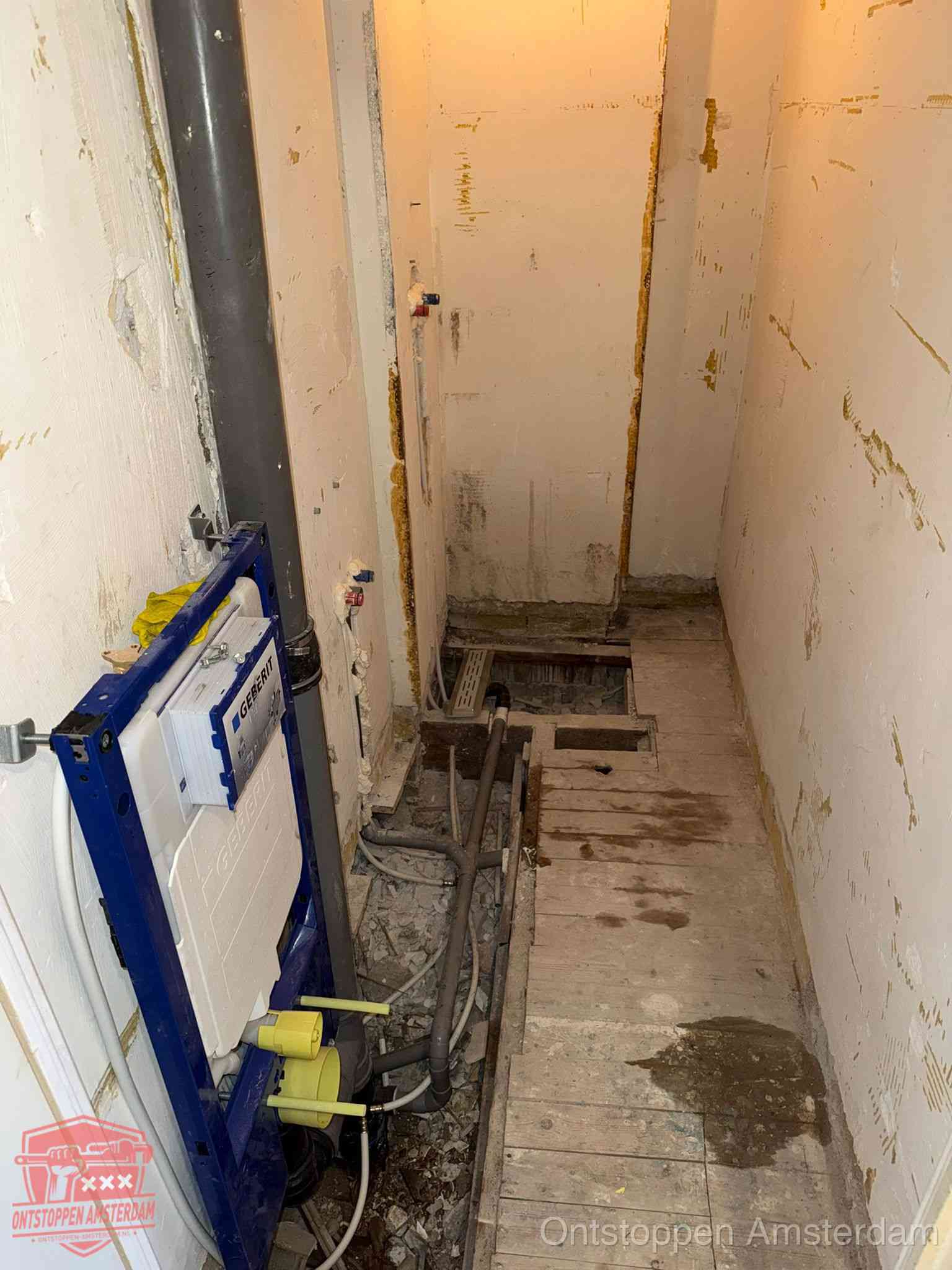 Een opgebroken toiletruimte tijdens renovatie met een Geberit inbouwreservoir en blootliggende oude afvoerleidingen, typisch voor oudere woningen in Amsterdam